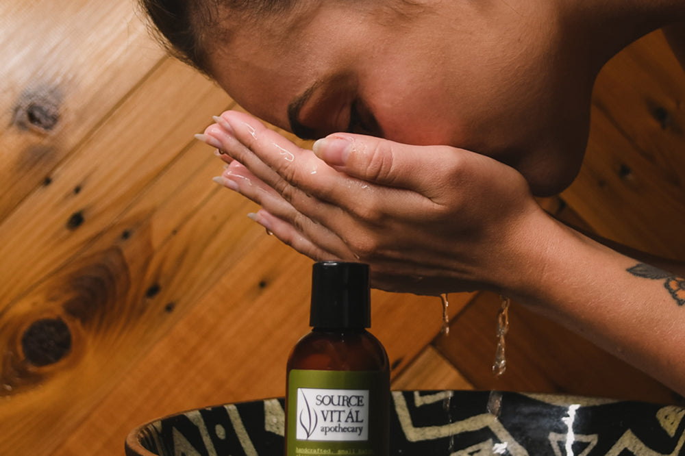 Woman leaning over a bowl washing her face