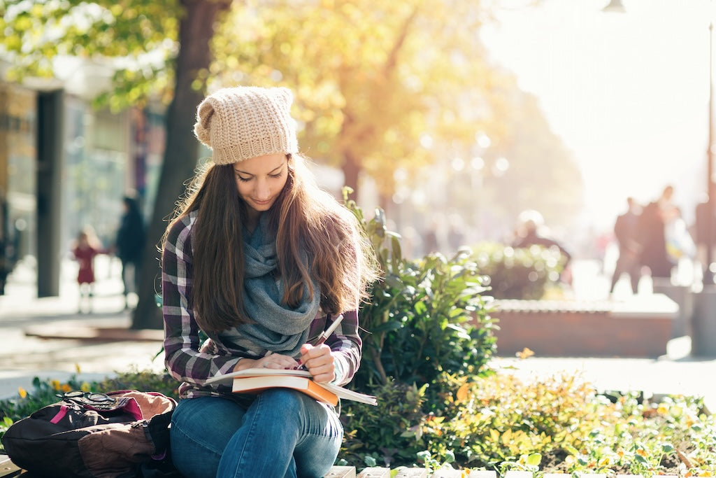 College student woman sitting writing in notebook