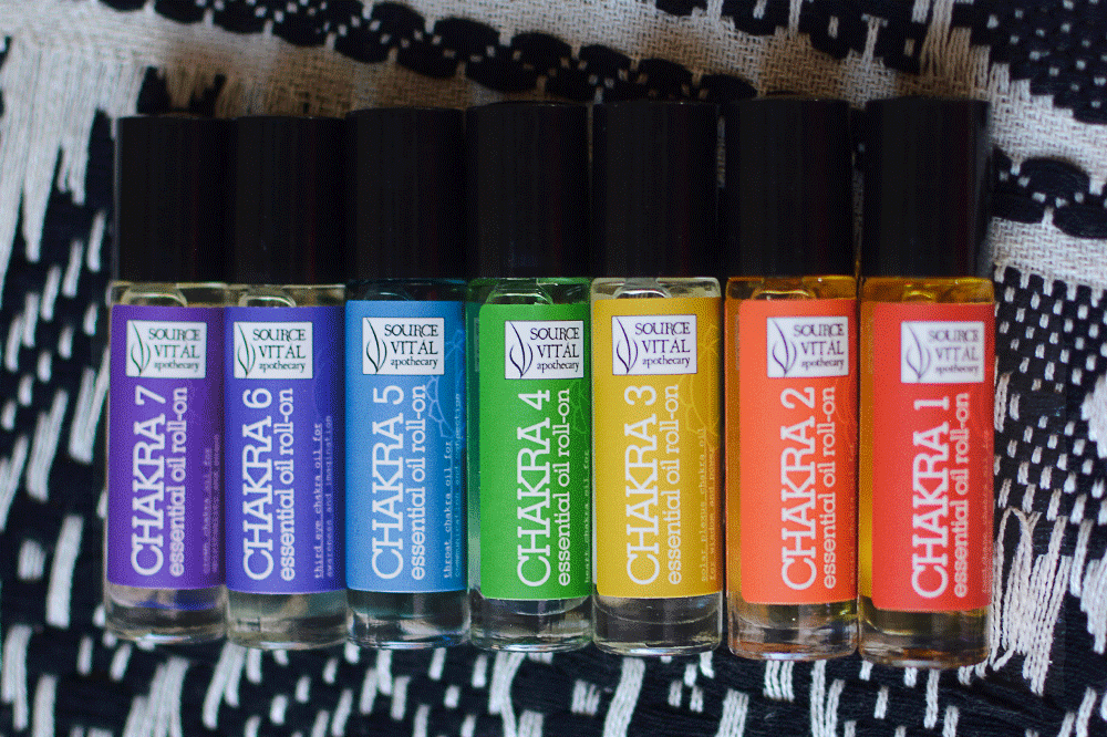 Seven Chakra Essential Oil Roll-Ons on black and white fabric background. 