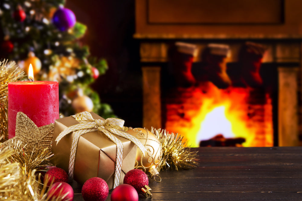 Presents and ornaments in front of tree a roaring fire