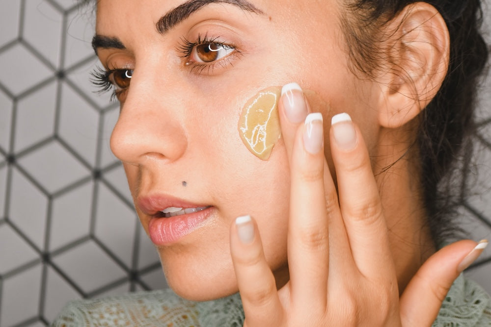 Woman exfoliating with Algae Deep Scrub on face