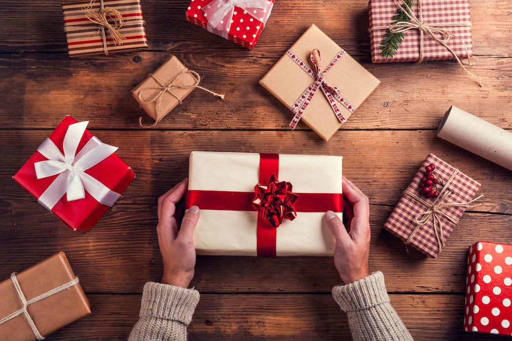 Woman wrapping gifts on table