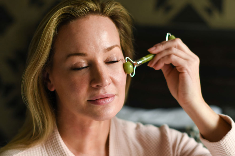 Woman Using Jade Facial Roller on her Skin
