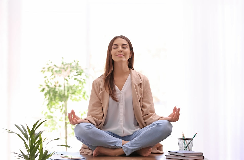 Woman surrounded by plants meditating