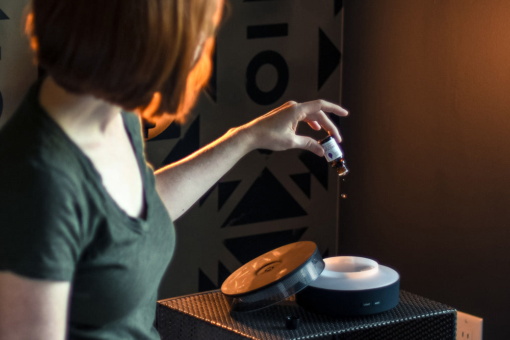 Woman putting essential oils in diffuser