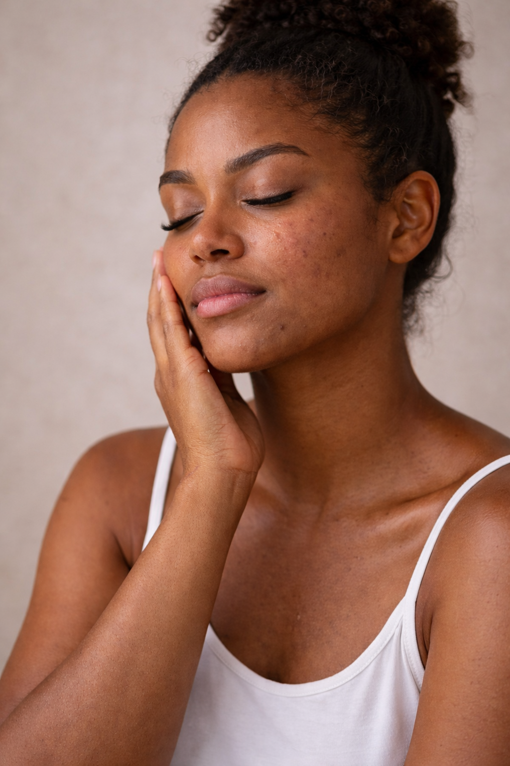 Woman with oily skin with hand on her face