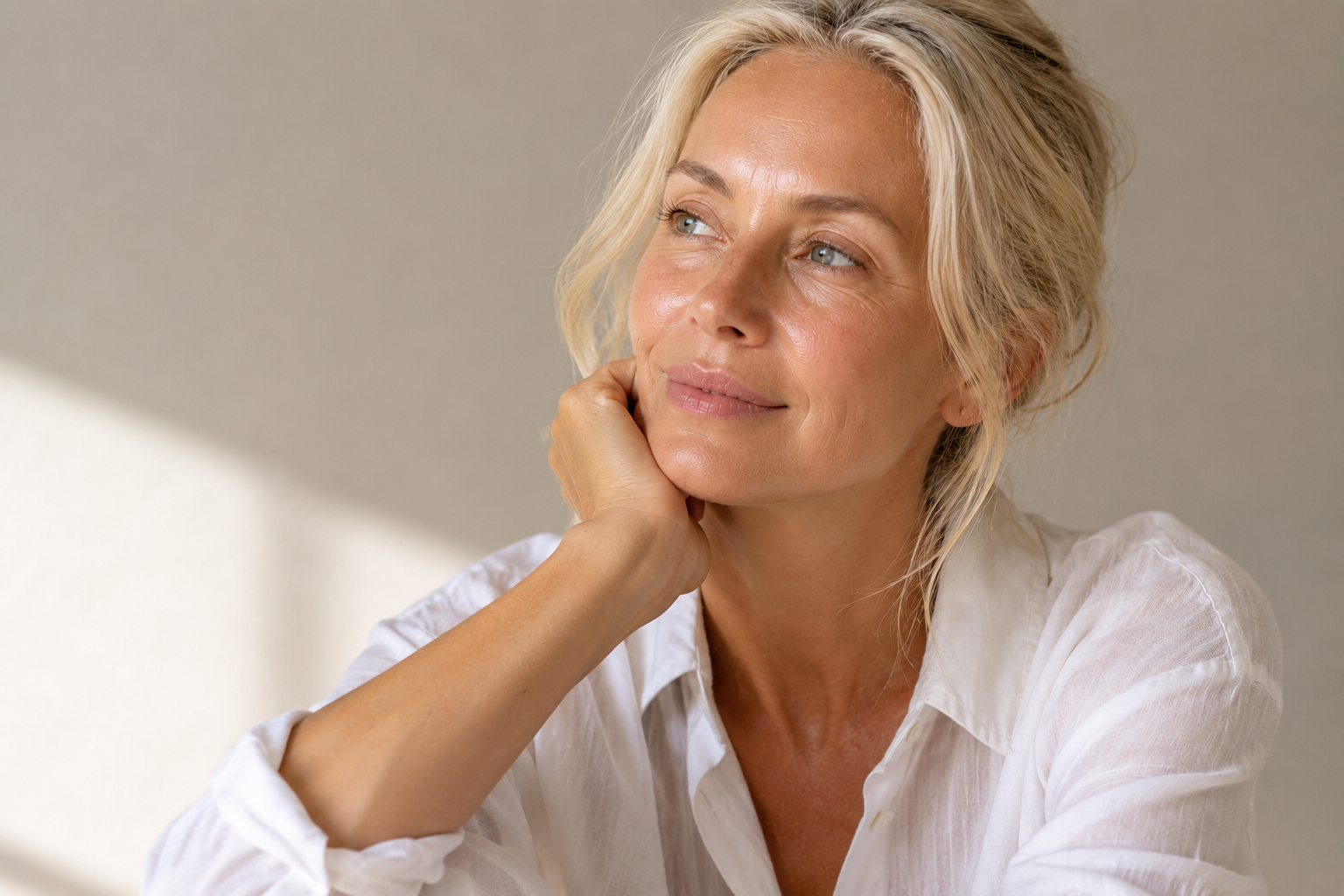 Mature woman with oily skin looking away in soft lighting