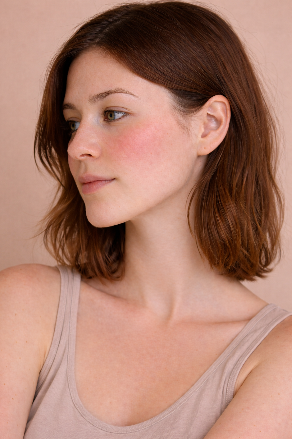 Woman with short red hair with redness on cheeks