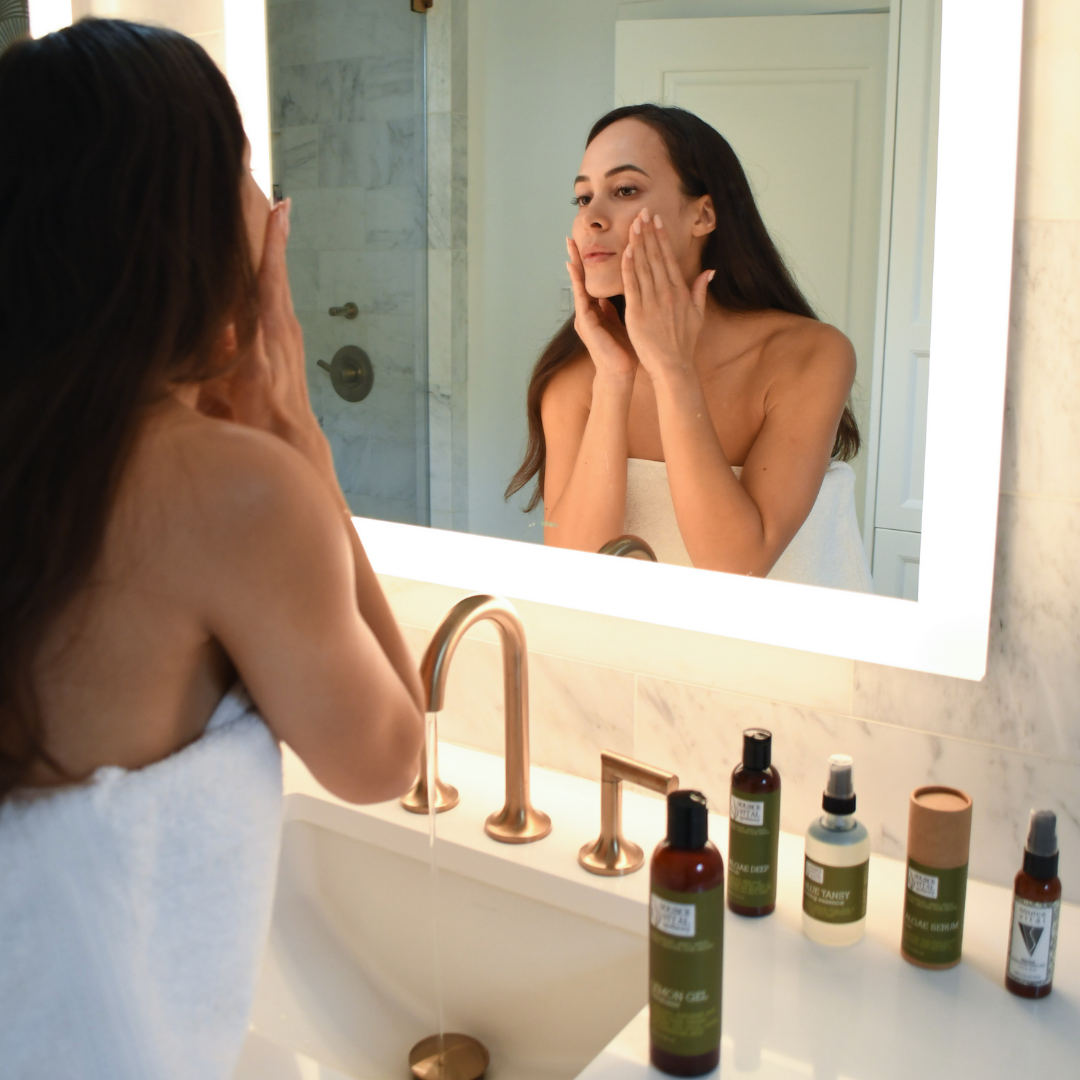 Woman applying cleanser to face