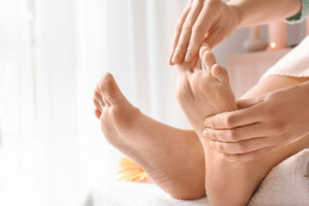 Woman performing reflexology massage on herself