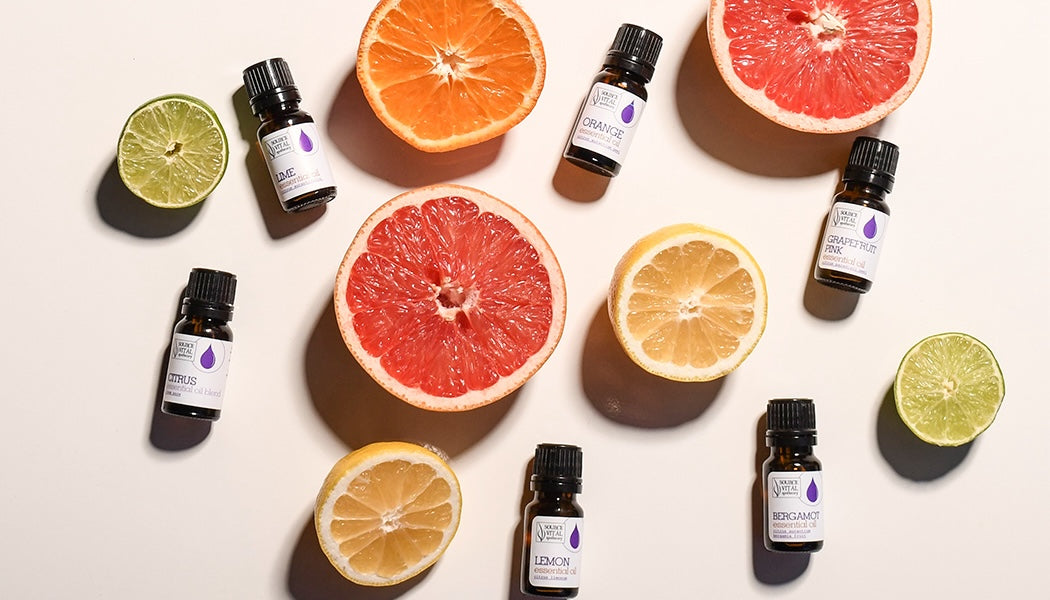 Source Vital Apothecary Citrus Essential Oils surrounded by cut citrus fruit halves