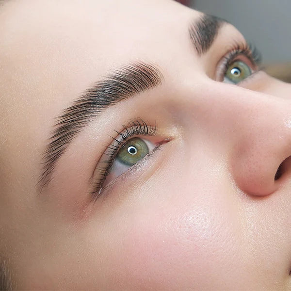 Woman with strong eyebrows and eyelashes looking up 