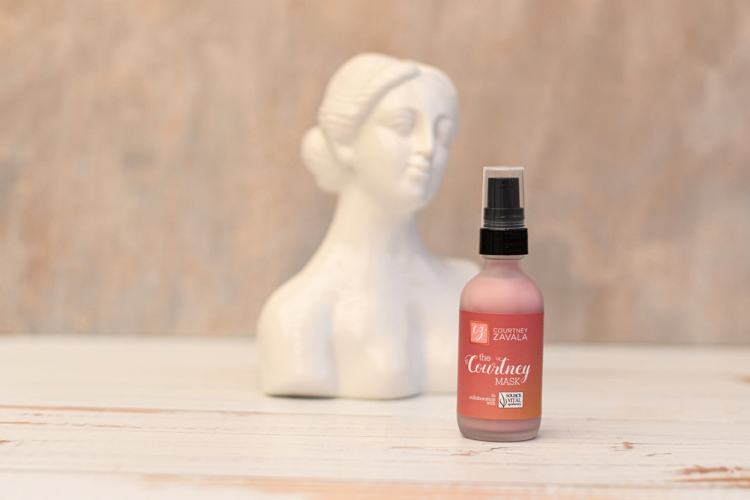 The Courtney Mask on marble table with bust of woman behind it