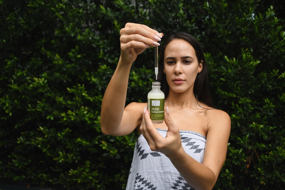 Woman holding dropper of Pure Toning Essence 
