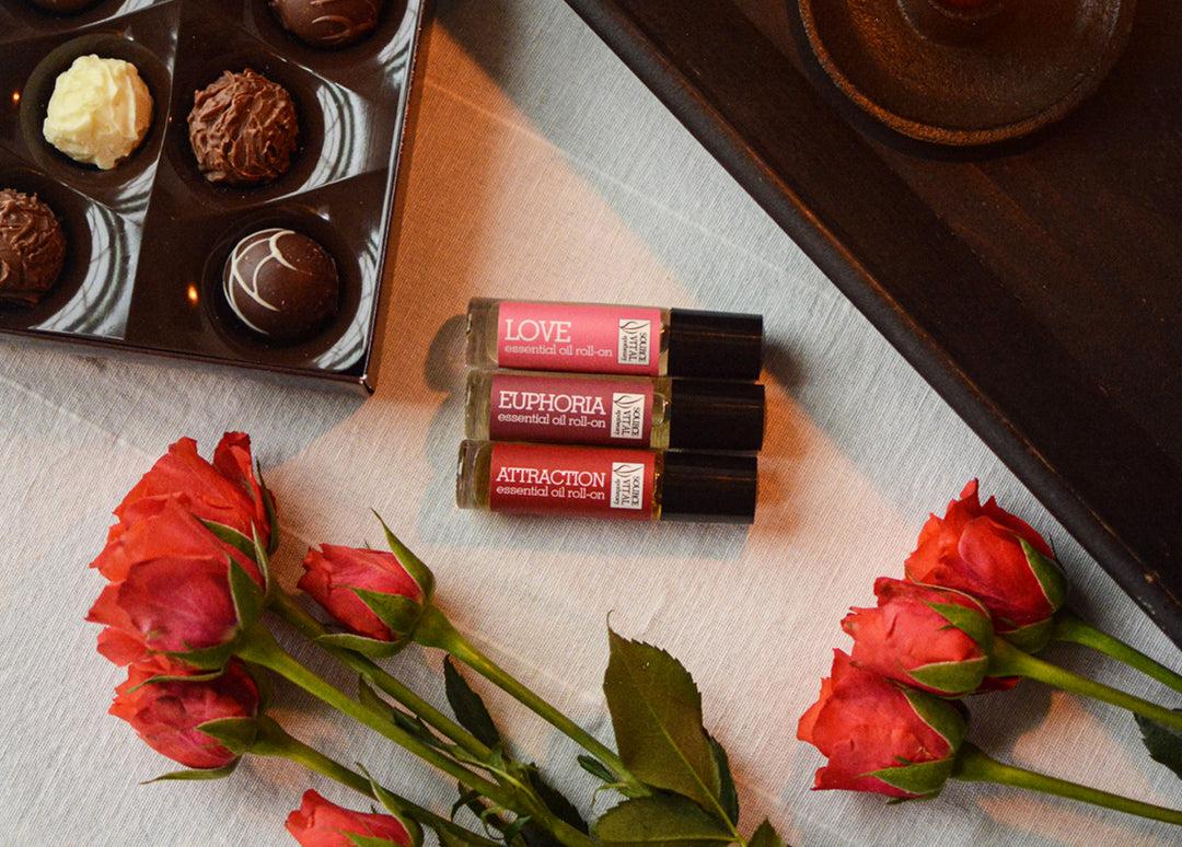 Source Vitál Apothecary Love Potions No. 3 Roll-On's with red roses and box of chocolates surrounding it