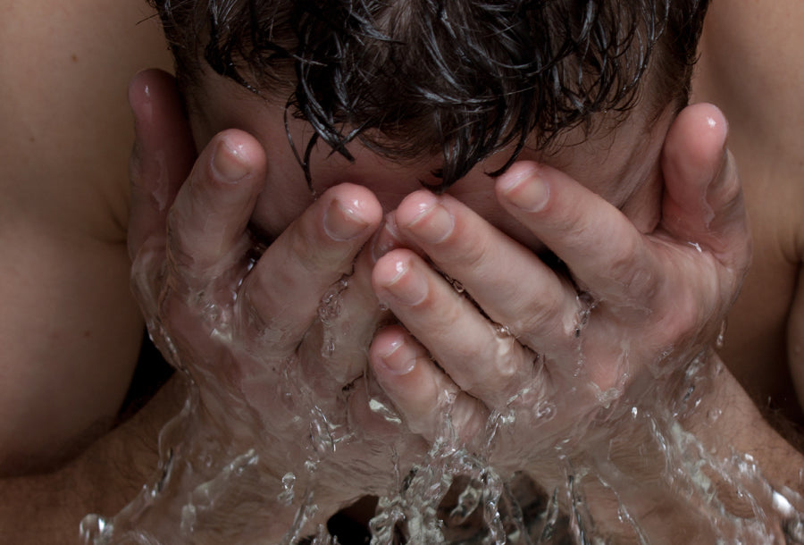 man splashing water on his face