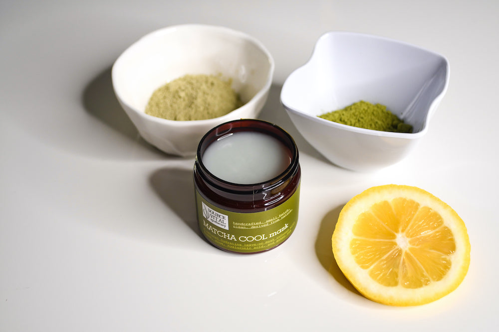 Source Vitál's Matcha Cool Mask surrounded by a cut lemon, small bowl of matcha powder, and small bowl of algae powder.