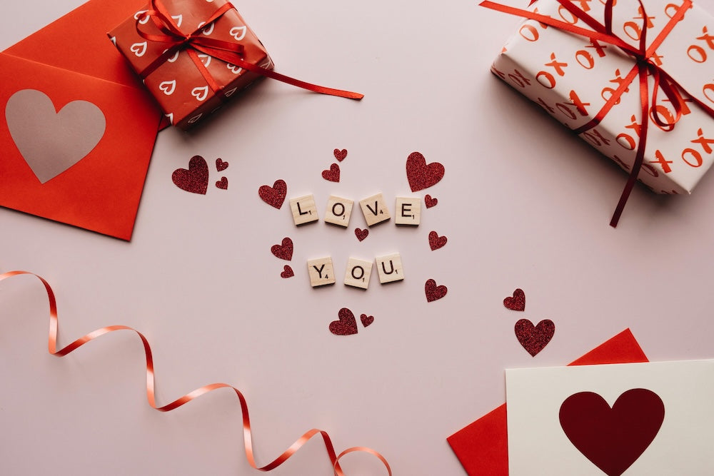 "love you" in scrabble pieces surrounded by gifts and cards
