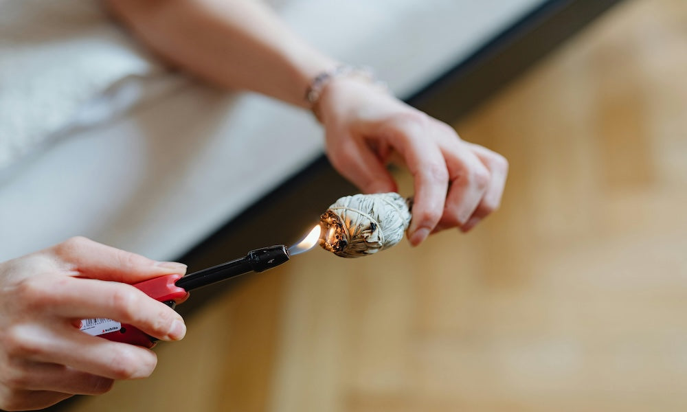 Woman lighting bundle of sage