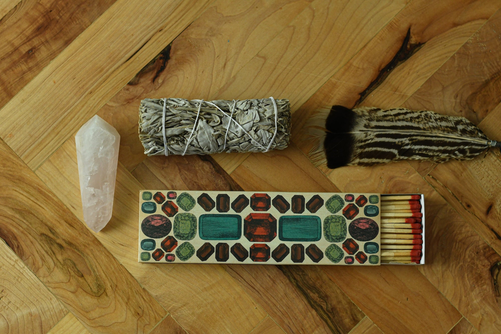 Sage bundle with matches, rose quartz crystal in the wild