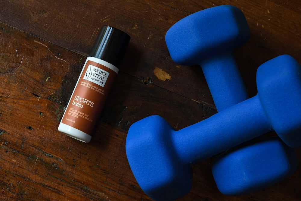 Sports balm next to blue hand weights