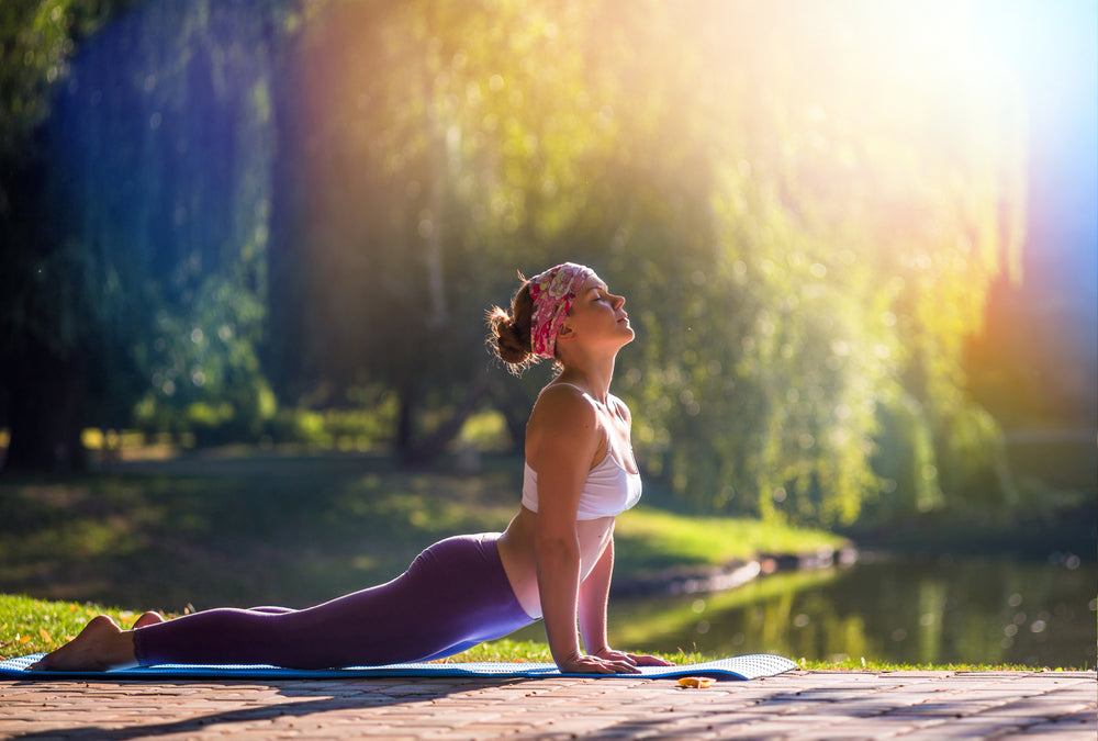 Woman doing yoga next to lake in nature
